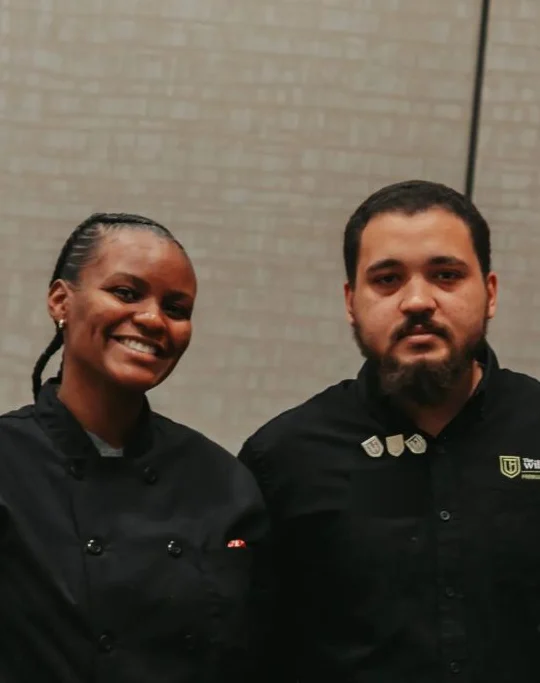 Two TWF hospitality team members in TWF chef and captain jackets